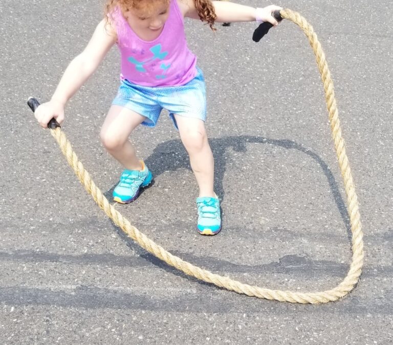 a little girl doing rope skipping on the road