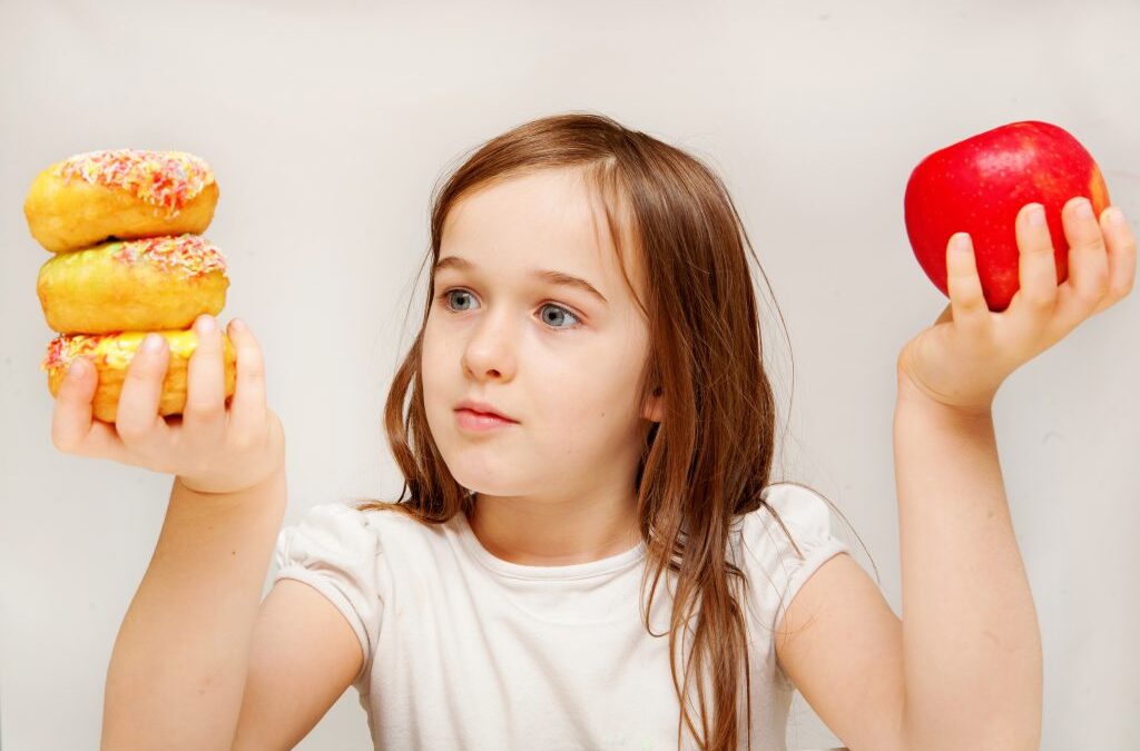 girl with an apple in one hand and donuts in another hand