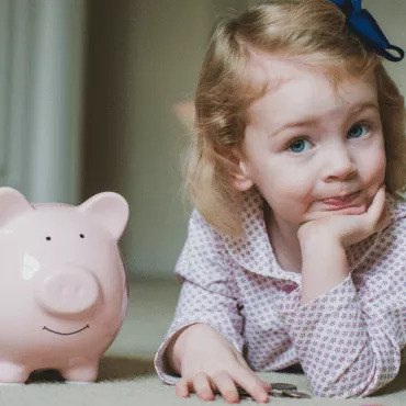 a cute little girl with a piggy bank