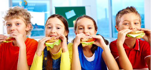 Four kids eating a cheese sandwich