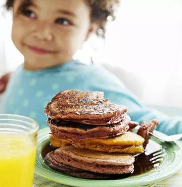 a plate full of pancakes and a glass of juice