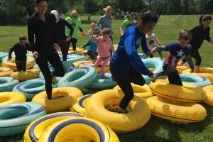 adults and kids crossing the rings in a mud run