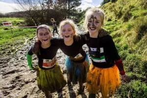 Three little girls in black tops are smiling