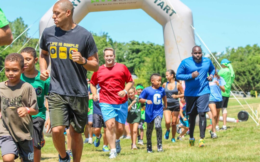 Three adults and kids running on the ground